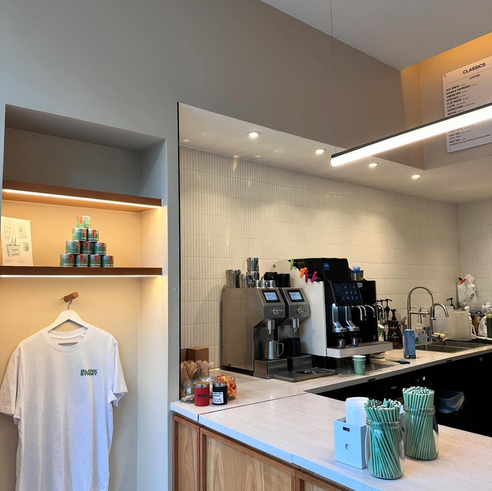 Two Übermilk ONE milk frothers side by side on the counter at a Blank Street coffee shop