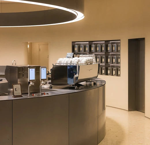 Two Übermilk ONE milk frothers on the curved stainless steel bar at WatchHouse
